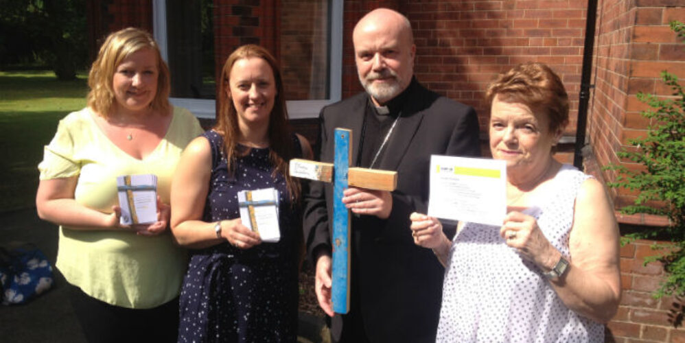 Bishop Marcus being presented with a Lampedusa cross