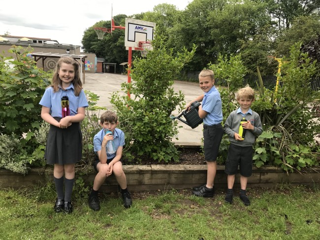 children in front of plants in garden