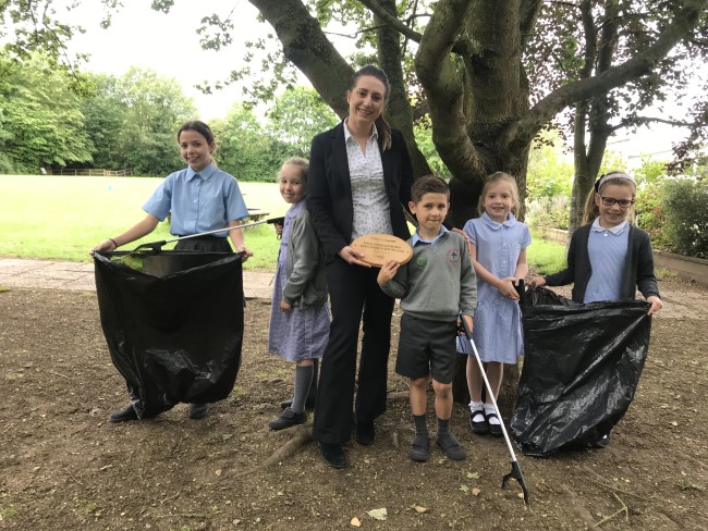 children clearing litter and holding plaque